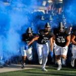 GVSU Football players run onto the field in front of blue smoke on November 2, 2024